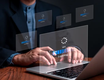 Person tippt auf Laptop; mehrere transparente Ladeanzeigen schweben über der Tastatur.