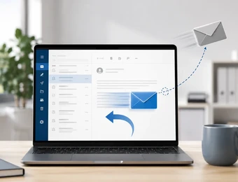 Offener Laptop auf Schreibtisch; E-Mail-Anwendung sichtbar, blauer Umschlag auf dem Bildschirm, schwebender Umschlag rechts.