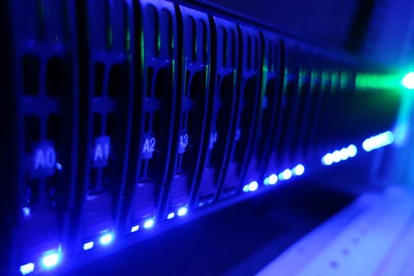 Serverrack mit mehreren Blades, blauen LEDs an der Front; rechts leuchtet eine helle grüne LED.