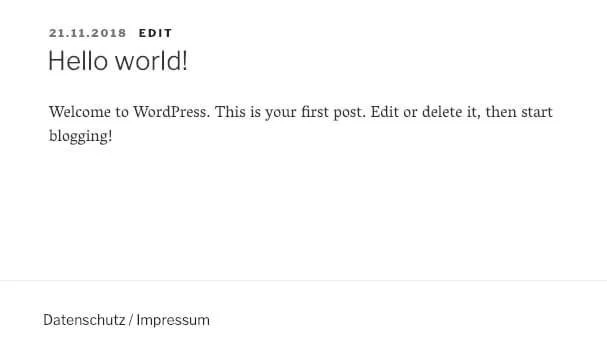Screenshot einer WordPress-Seite: Überschrift Hello world! Datum 21.11.2018, Textbeginn; Footer: Datenschutz / Impressum.