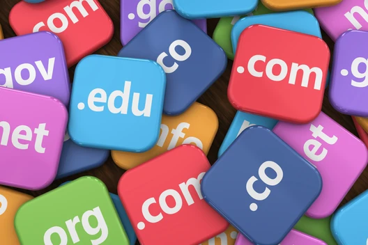 Viele bunte, quadratische Kacheln mit Domain-Endungen wie .com, .net, .org, .edu, in Rot, Blau, Pink und Grün.
