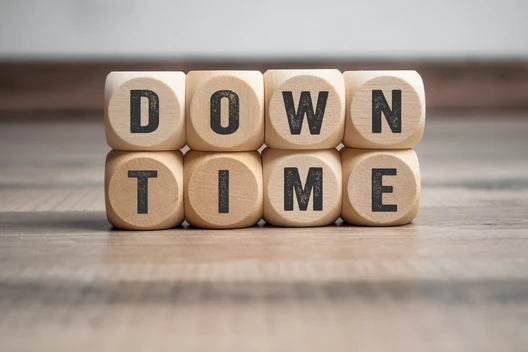 Acht Holzwürfel aus Holz mit schwarzen Buchstaben; oben bilden sie 'DOWN', unten 'TIME'.